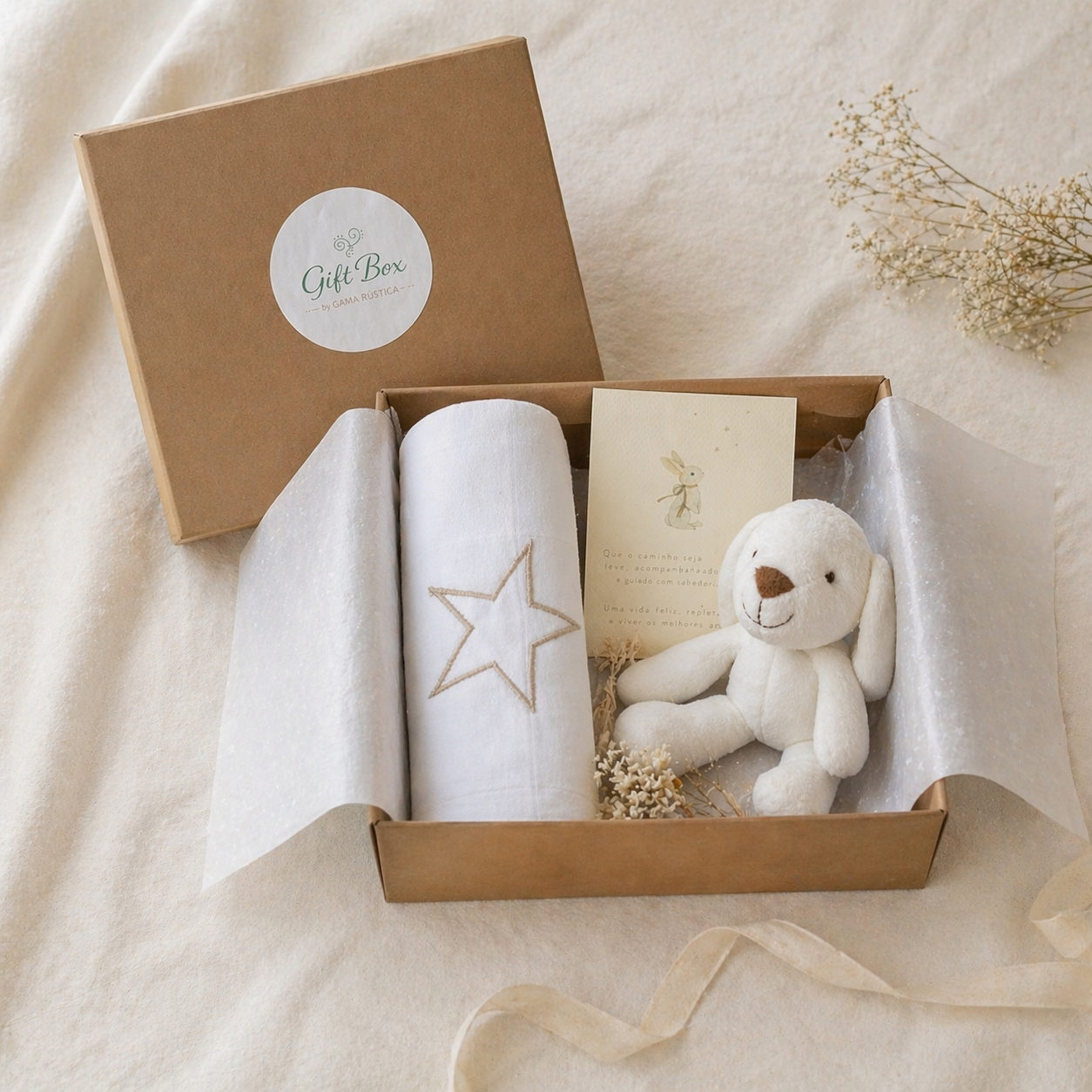 Caixa de presente com manta branca, peluche de cão branco e cartão em fundo bege.