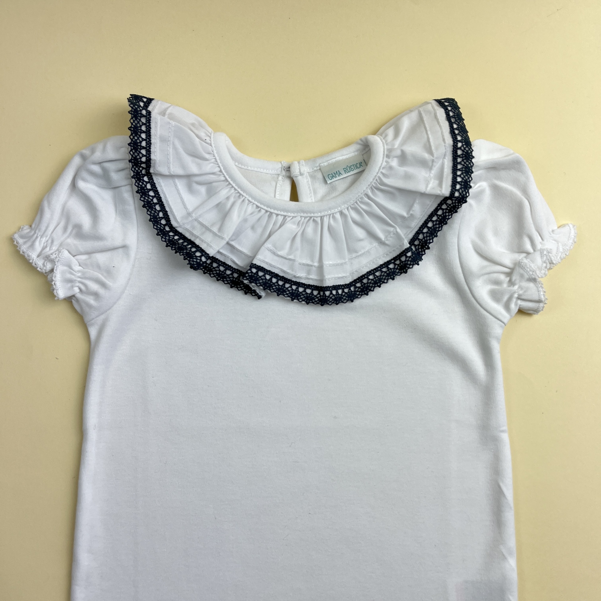 Camisola branca de manga curta com gola franzida e detalhe de renda preta