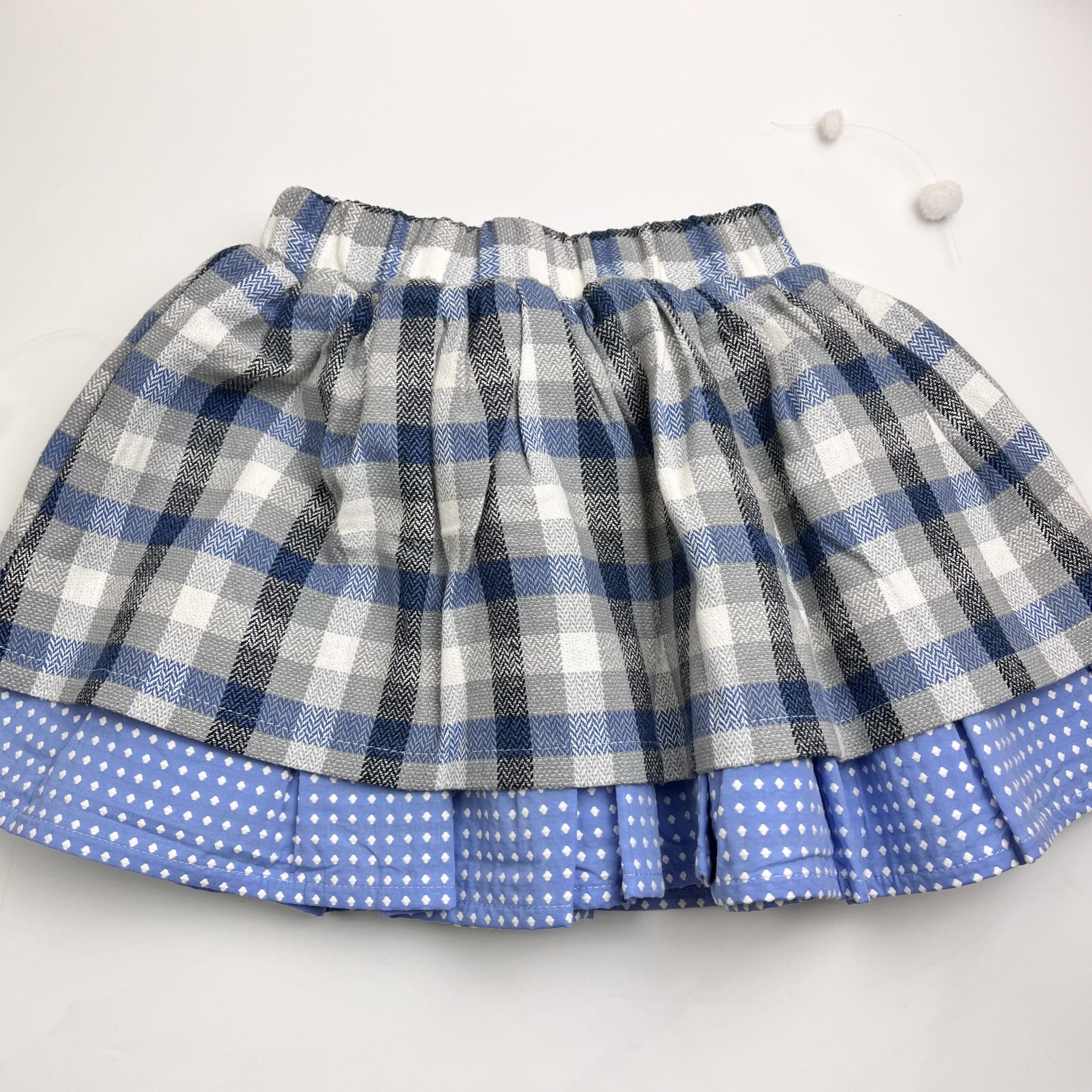 Saia infantil xadrez cinza, branco e azul com barra azul de bolinhas brancas