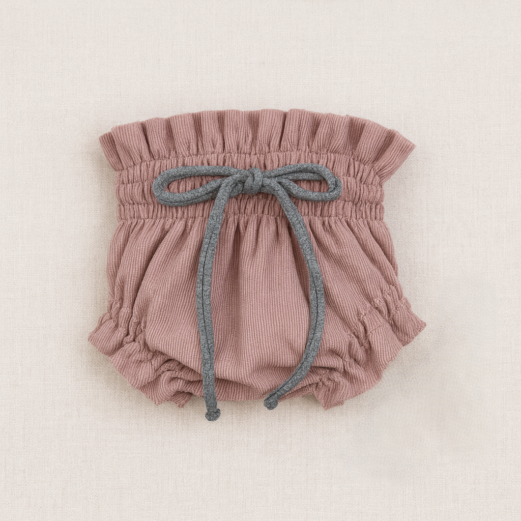 Cueca para bebé rosa antigo com cordão cinzento e textura fina sobre fundo claro