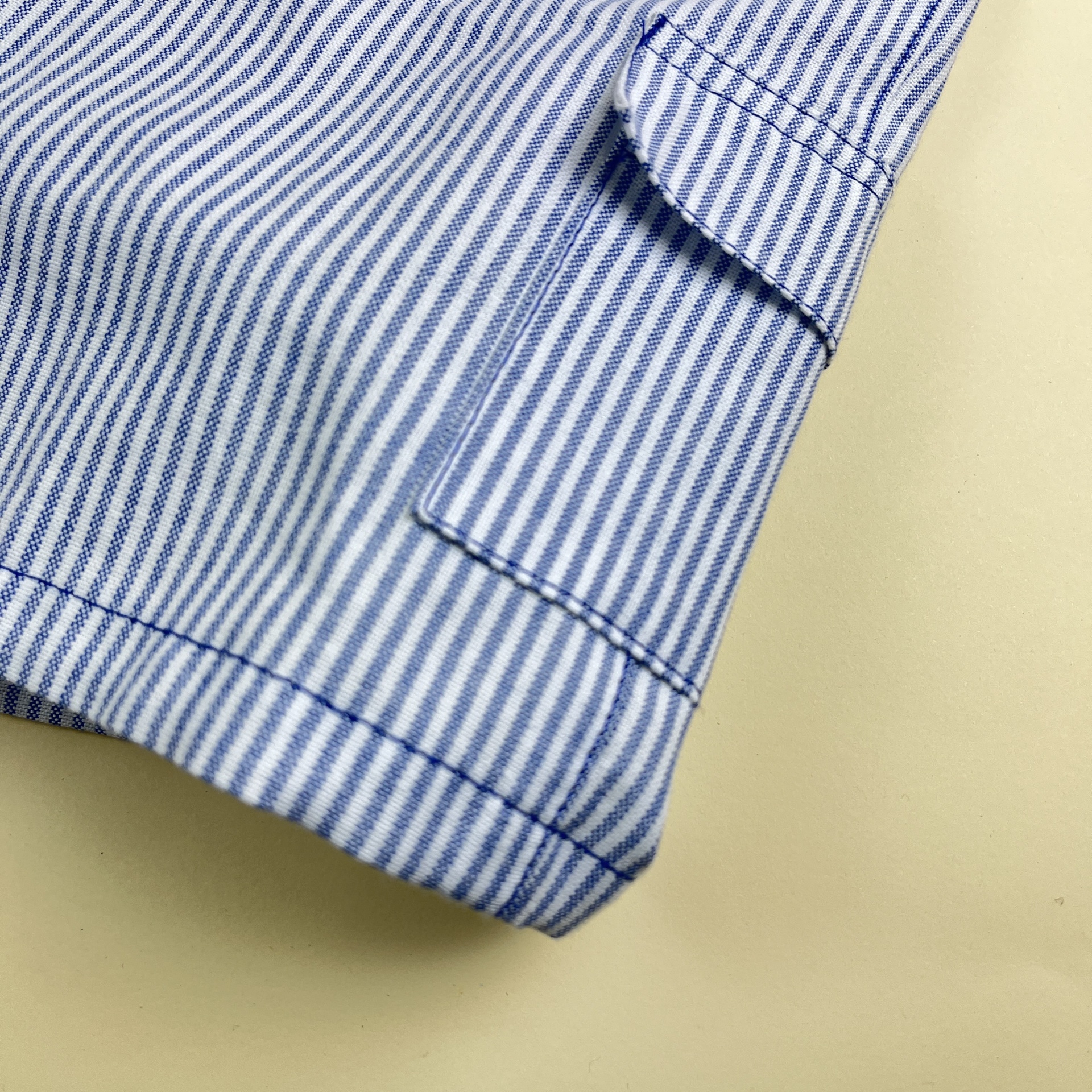 Manga de camisa às riscas azuis e brancas com costura detalhada