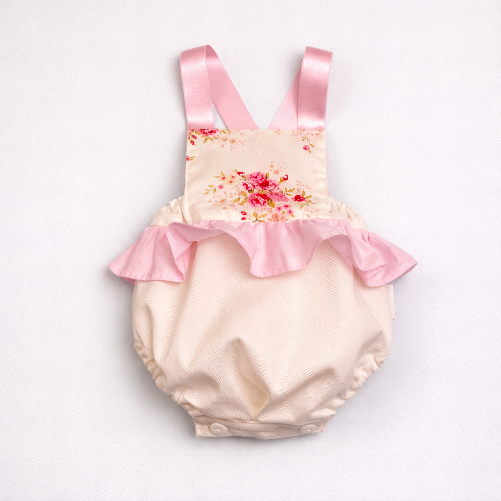 Roupa de bebé bege com alças rosas e folhos