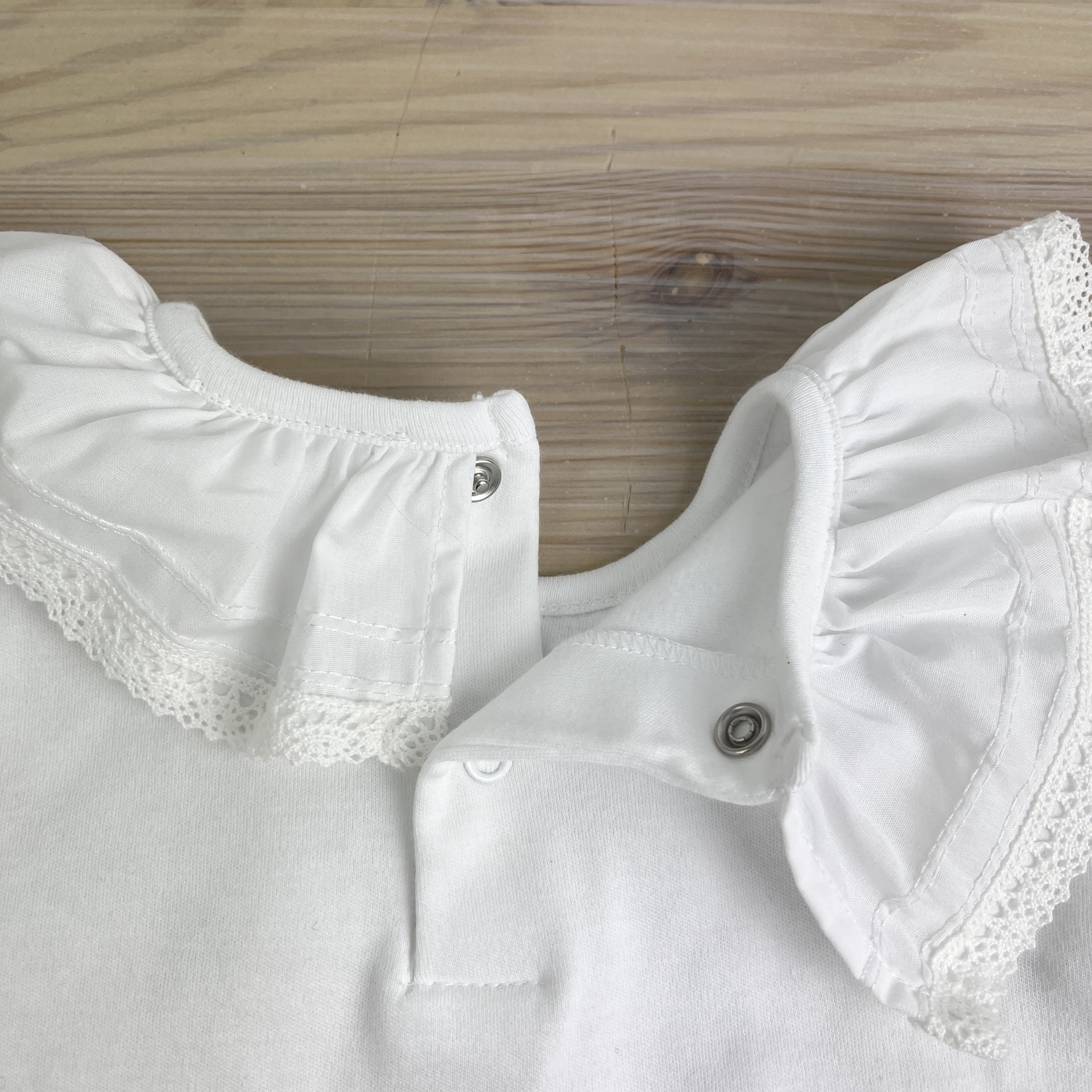 Colarinho branco com folhos e botões de pressão metálicos