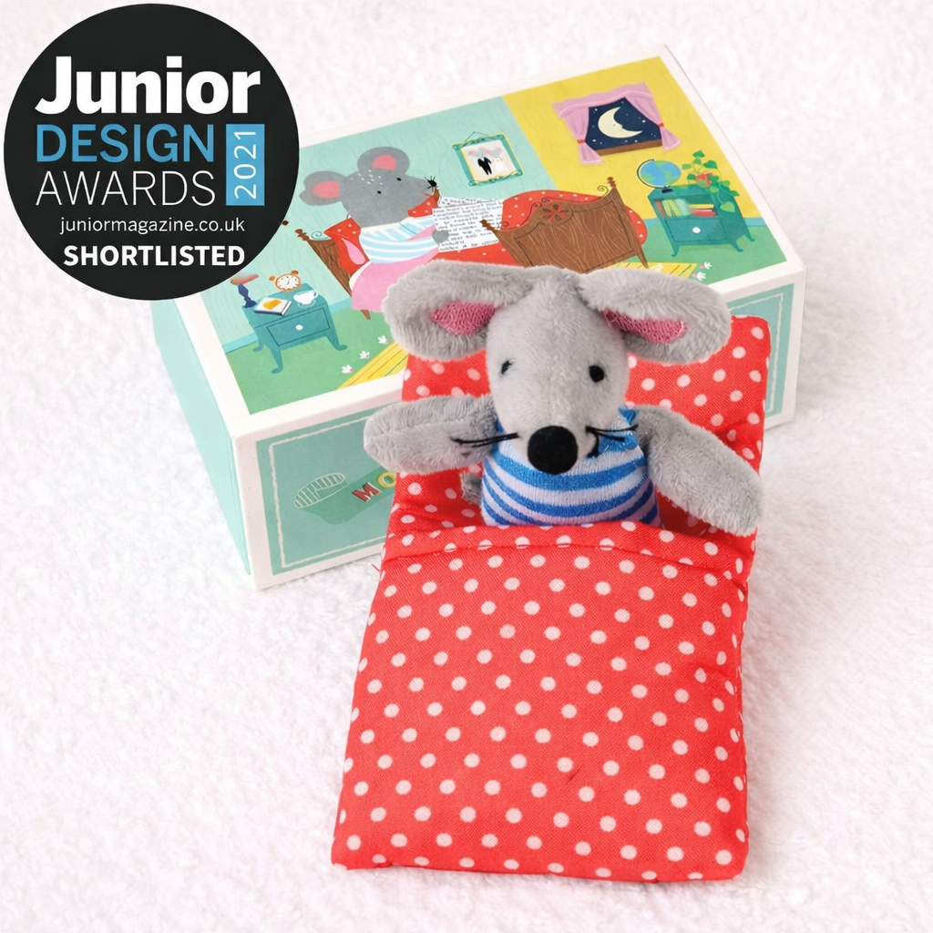 Brinquedo rato de peluche na cama com roupa vermelha e bolinhas brancas