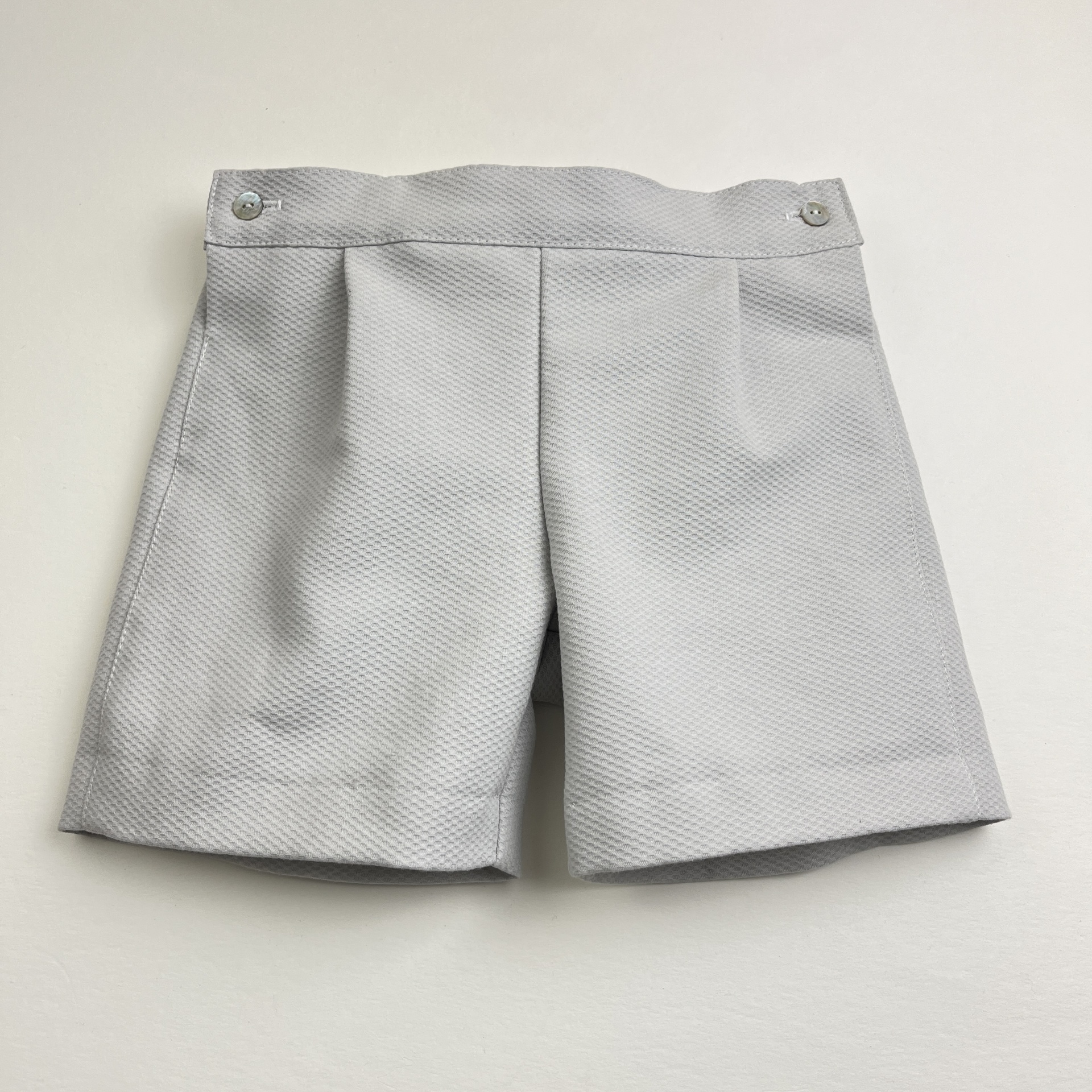 Calções cinzentos de tecido com botões prateados