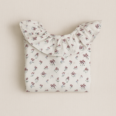 Blusa branca com padrão de pequenas flores vermelhas e verdes e folho na gola