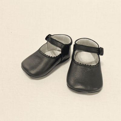 Sapatos infantis pretos de couro com alças e bordas decorativas