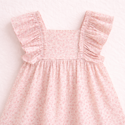 Vestido infantil rosa claro com padrão floral e folhos nas alças