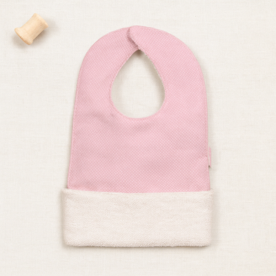 Babete de bebé rosa e creme com bobina de madeira