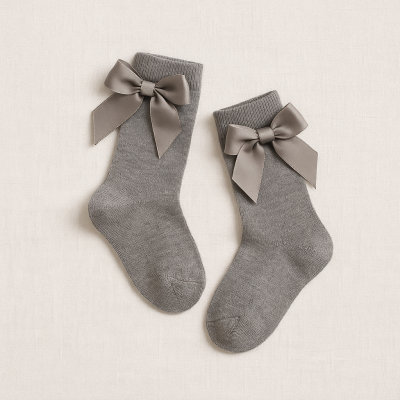 Meias cinzentas com laços de fita cinza escuro sobre fundo branco.