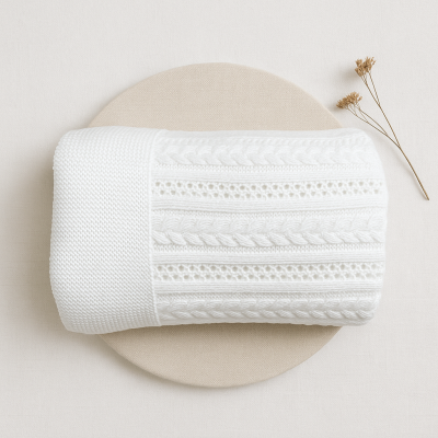 Manta branca trançada com padrões, base redonda bege e ramos secos