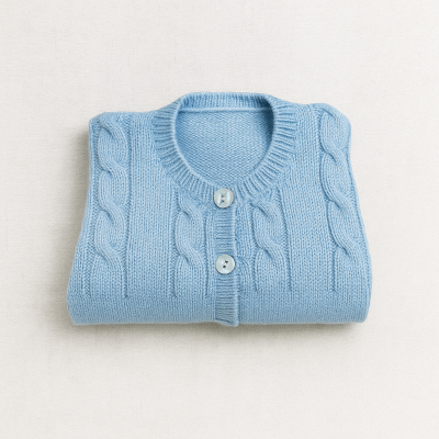 Casaco de malha azul claro dobrado com botões