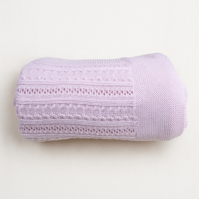 Cobertor lilás com padrão trançado e texturas variadas dobrado