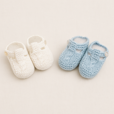 Dois pares de sapatinhos de bebé tricotados, branco e azul claro, com botão lateral.