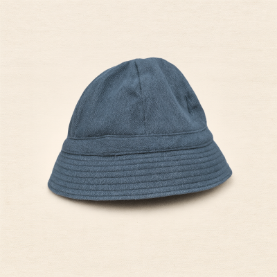 Chapéu tipo balde em tecido azul escuro sobre fundo bege