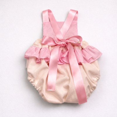 Macacão para bebé rosa e creme com folhos e laço de cetim