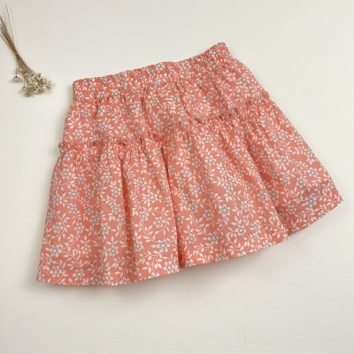 Saia infantil cor salmão com flores brancas e babados