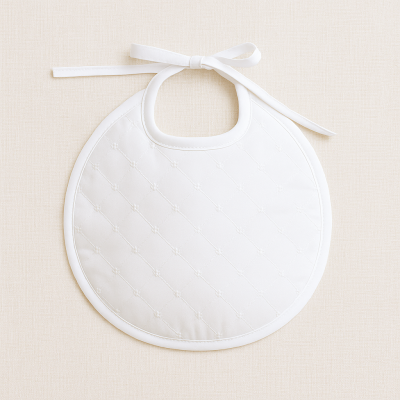 Babete redondo branco acolchoado com padrão de losangos e laço para amarrar