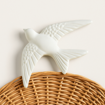 Escultura decorativa de pássaro branco em cerâmica sobre cesta de vime