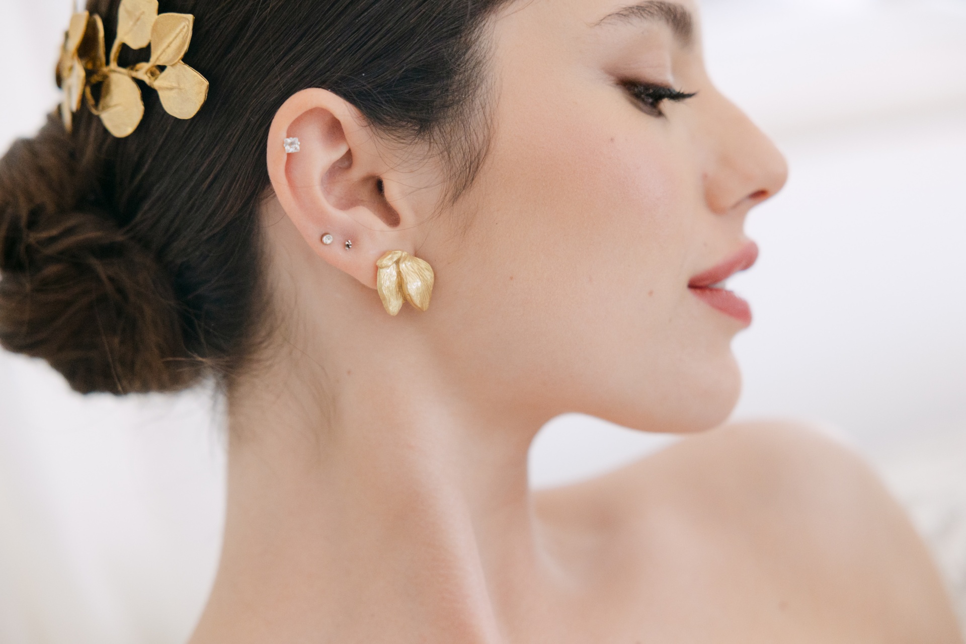 Folliete Mulher com brinco dourado e piercing na orelha