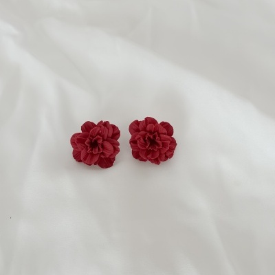 Brincos flor vermelha sobre tecido branco