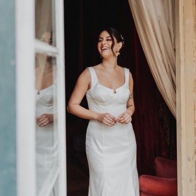 Mulher com vestido de noiva branco junto a uma janela