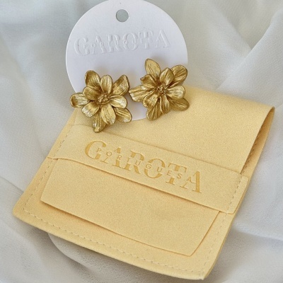 Brincos flor dourados com embalagem da marca CAROÉA