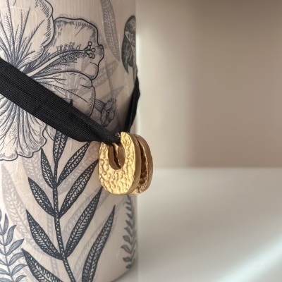 Vaso cerâmico com padrão floral e fita preta com ornamento dourado