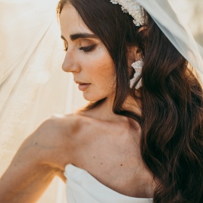 Noiva com vestido branco, véu e faixa branca na cabeça