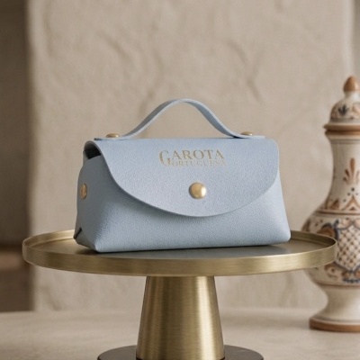 Bolsa azul claro com fecho botão dourado em suporte dourado redondo