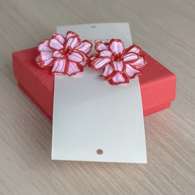 Brincos florais rosa com detalhes vermelhos numa caixa vermelha