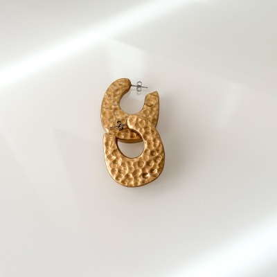 Brincos dourados com textura martelada em fundo branco