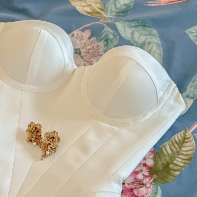 Corset branco estruturado sobre tecido azul com flores