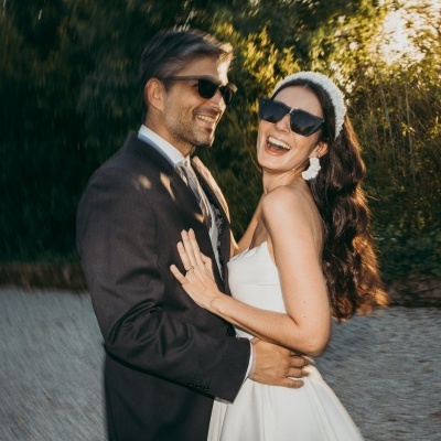 Casal vestido formalmente ao ar livre com óculos de sol