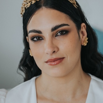 Mulher com auréola dourada floral e brincos correspondentes