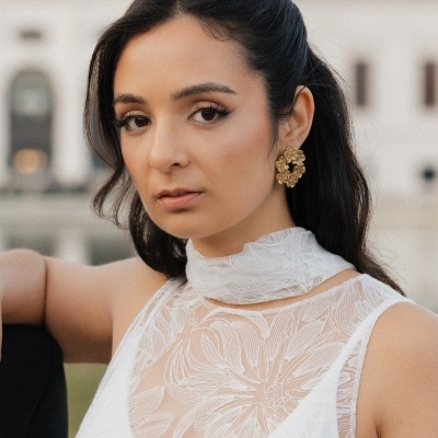 Mulher com vestido branco de renda e brincos dourados grandes