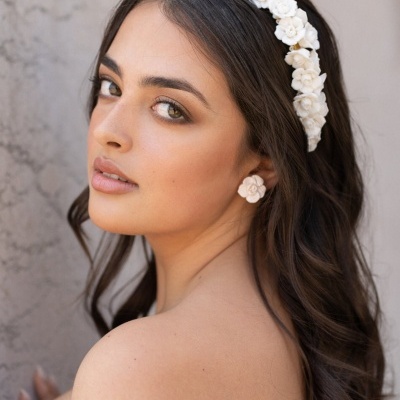 Mulher com tiara de flores brancas e brincos de flor