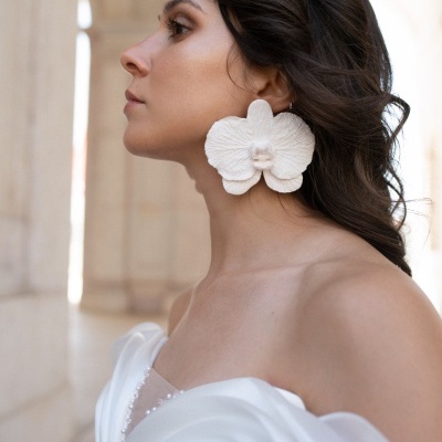 Brincos florais grandes brancos em mulher com vestido branco