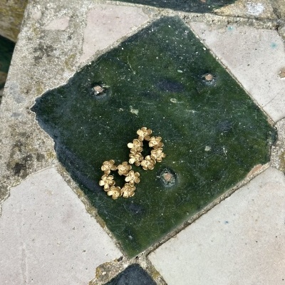 Brincos dourados em azulejos antigos verdes e beges
