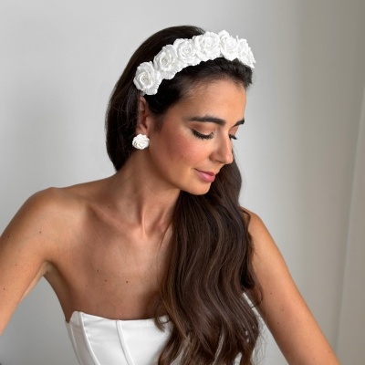 Mulher com faixa de cabelo branca de flores e vestido branco