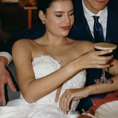 Vestido de noiva branco com detalhes em renda e mulher segurando cocktail