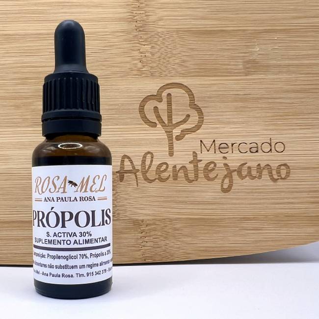 Própolis Frasco de própolis com conta-gotas frente a placa de madeira com gravação Mercado Alentejano