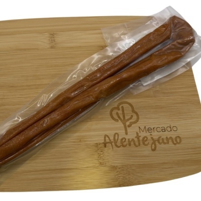 Enchidos embalados a vácuo sobre tábua de madeira com inscrição Mercado Alentejano
