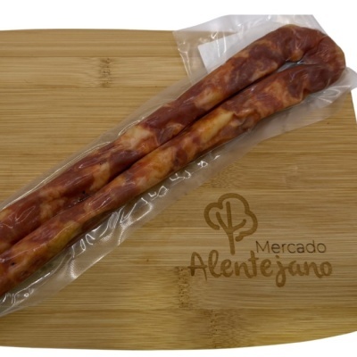 Dois enchidos embalados a vácuo num tabuleiro de madeira clara com a inscrição Mercado Alentejano.
