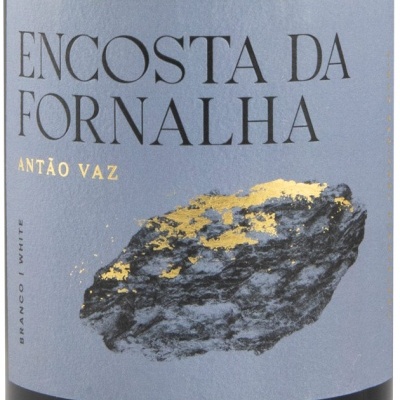 Etiqueta de vinho azul com texto preto e amarelo e imagem de rocha dourada