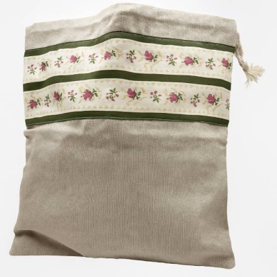 Saco de tecido bege com padrão floral e fecho de cordão