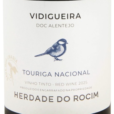 Rótulo branco de vinho tinto com pássaro azul e texto em preto e dourado