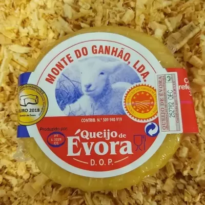Queijo de Évora D.O.P. redondo embalado com rótulo branco e vermelho e imagem de ovelha