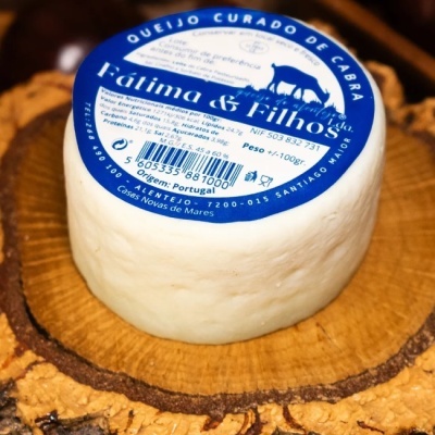 Queijo curado de cabra da marca Fátima & Filhos com rótulo azul e branco sobre base de madeira