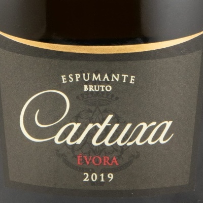 Garrafa de espumante com etiqueta preta e texto branco e vermelho